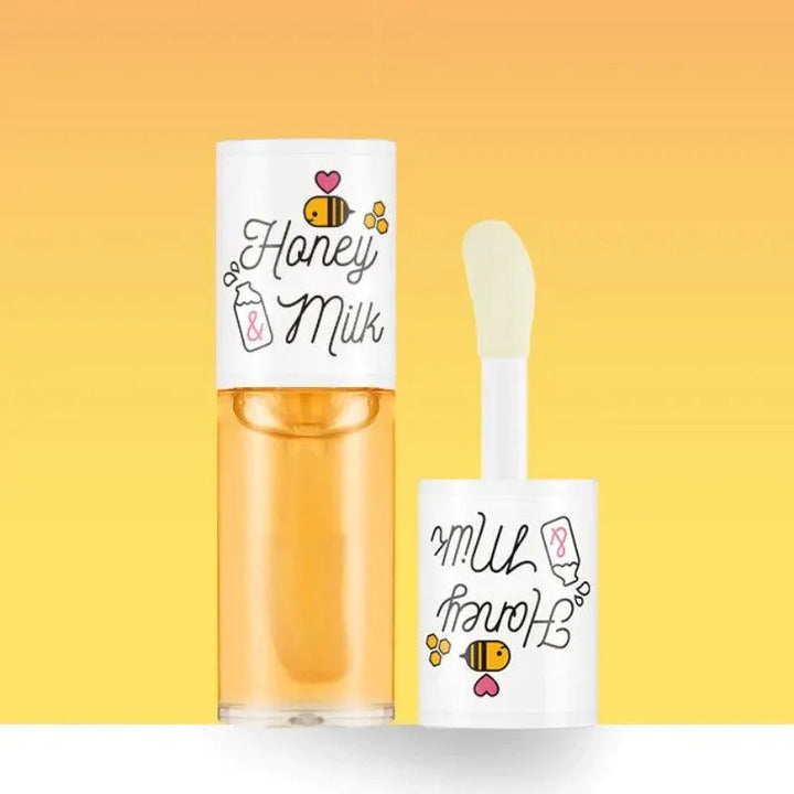 A'pieu Honey and Milk Lip Oil bottle and applicator on a yellow gradient background, Korean skincare.