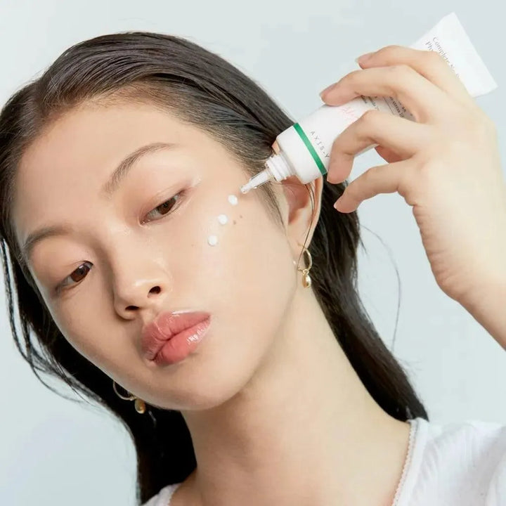 Woman applying Axis-Y sunscreen to face, Korean skincare product at Me Time Groningen