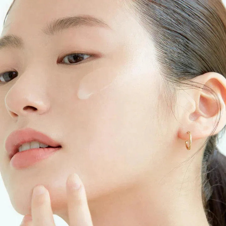 Woman applying Korean skincare serum to face, glowing skin, Me Time Groningen