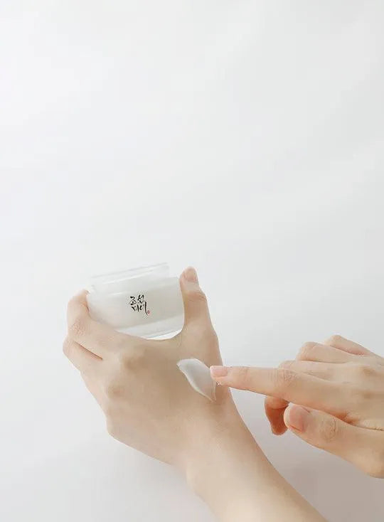 Applying Beauty of Joseon Dynasty Cream, Korean skincare product, on hand in minimal setting