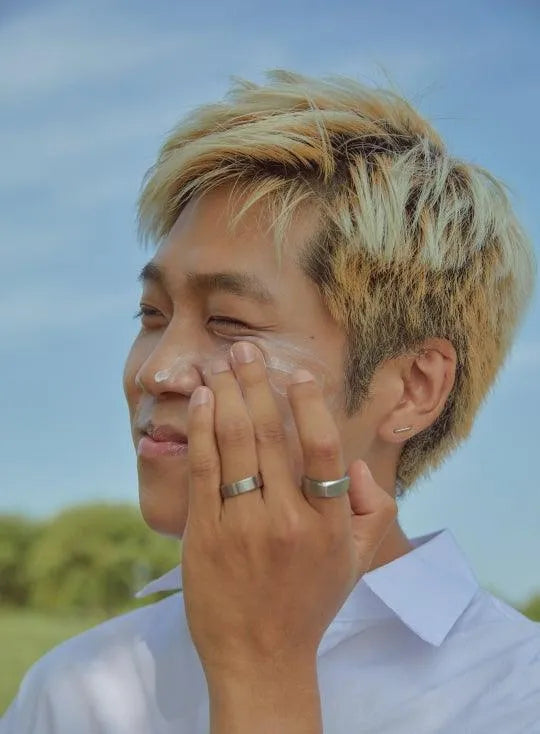 Man applying sunscreen outdoors, promoting Korean skincare from Me Time Groningen