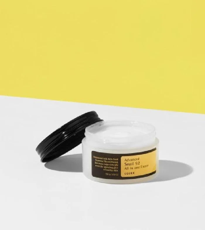 COSRX Advanced Snail 92 All In One Cream jar on white surface with yellow background, Korean skincare