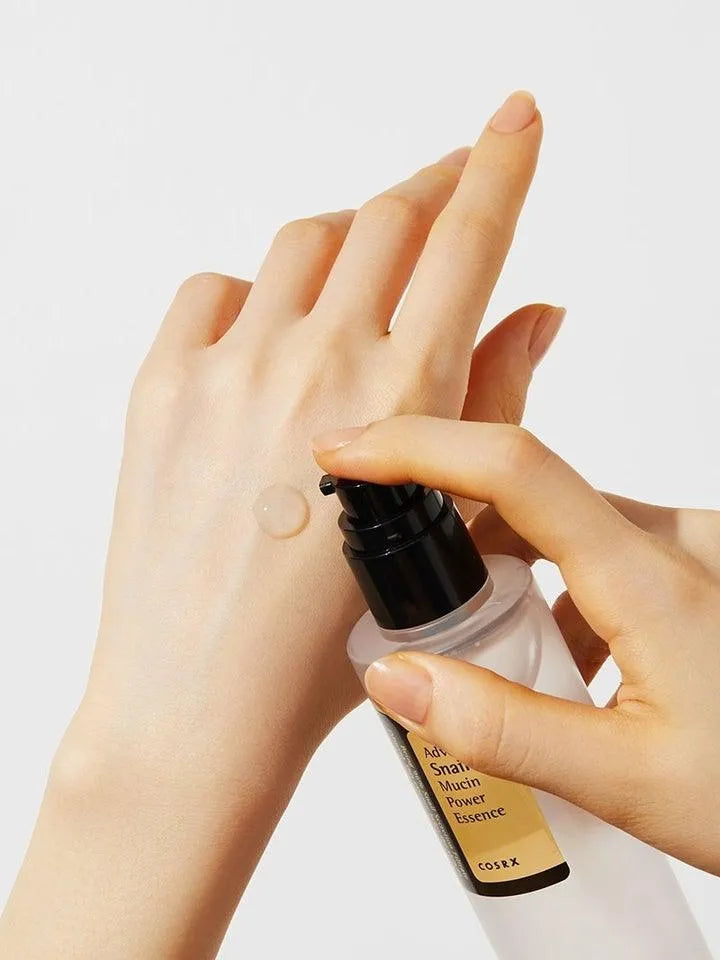 Applying COSRX Advanced Snail 96 Mucin Power Essence to hand, Korean skincare product