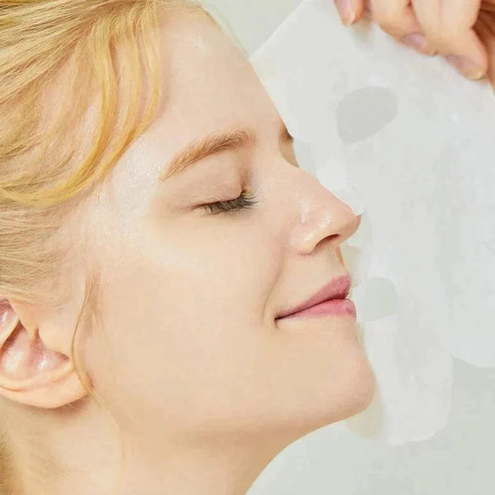 Woman applying COSRX Advanced Snail Mucin Power Sheet Mask, Korean skincare at Me Time Groningen