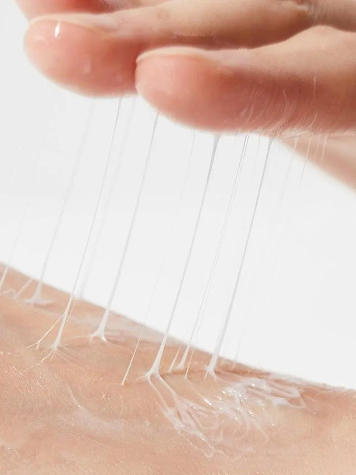 Hand applying COSRX Advanced Snail Peptide Eye Cream texture on skin, Korean skincare