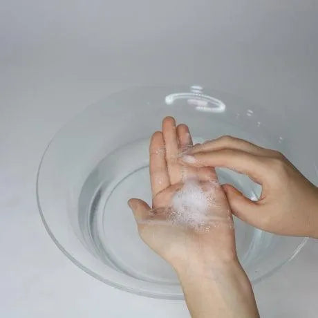 Hand holding Dr. Ceuracle Pro Balance Morning Enzyme Wash powder near water bowl, Korean skincare