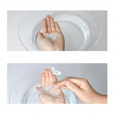 Hands lathering Dr. Ceuracle Pro Balance Night Enzyme Wash above a clear water bowl