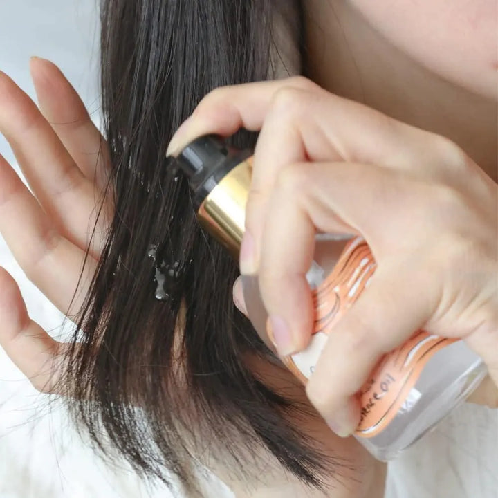Applying Elizavecca CER-100 hair essence oil to hair, Korean skincare product Nederland