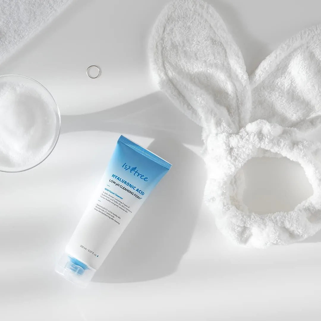 Isntree hyaluronic acid low pH cleansing foam, fluffy bunny headband, and foam on white surface