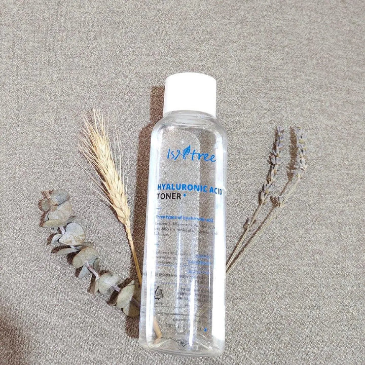 Isntree Hyaluronic Acid Toner bottle on fabric with dried plants, Korean skincare Nederland
