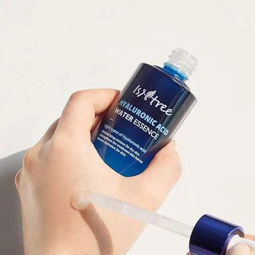Hand holding Isntree Hyaluronic Acid Water Essence bottle with dropper, Korean skincare product