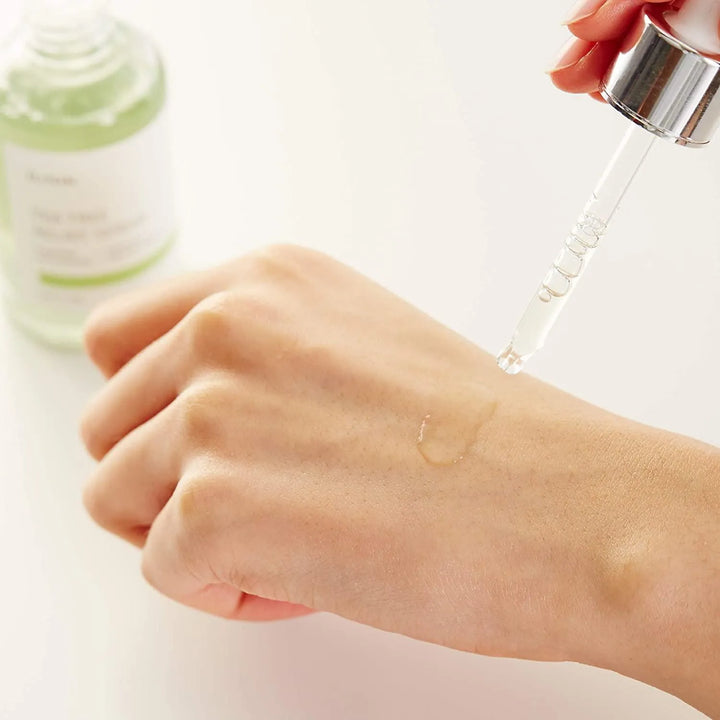 Applying iUNIK Tea Tree Relief Serum with dropper on hand, Korean skincare at Me Time Groningen