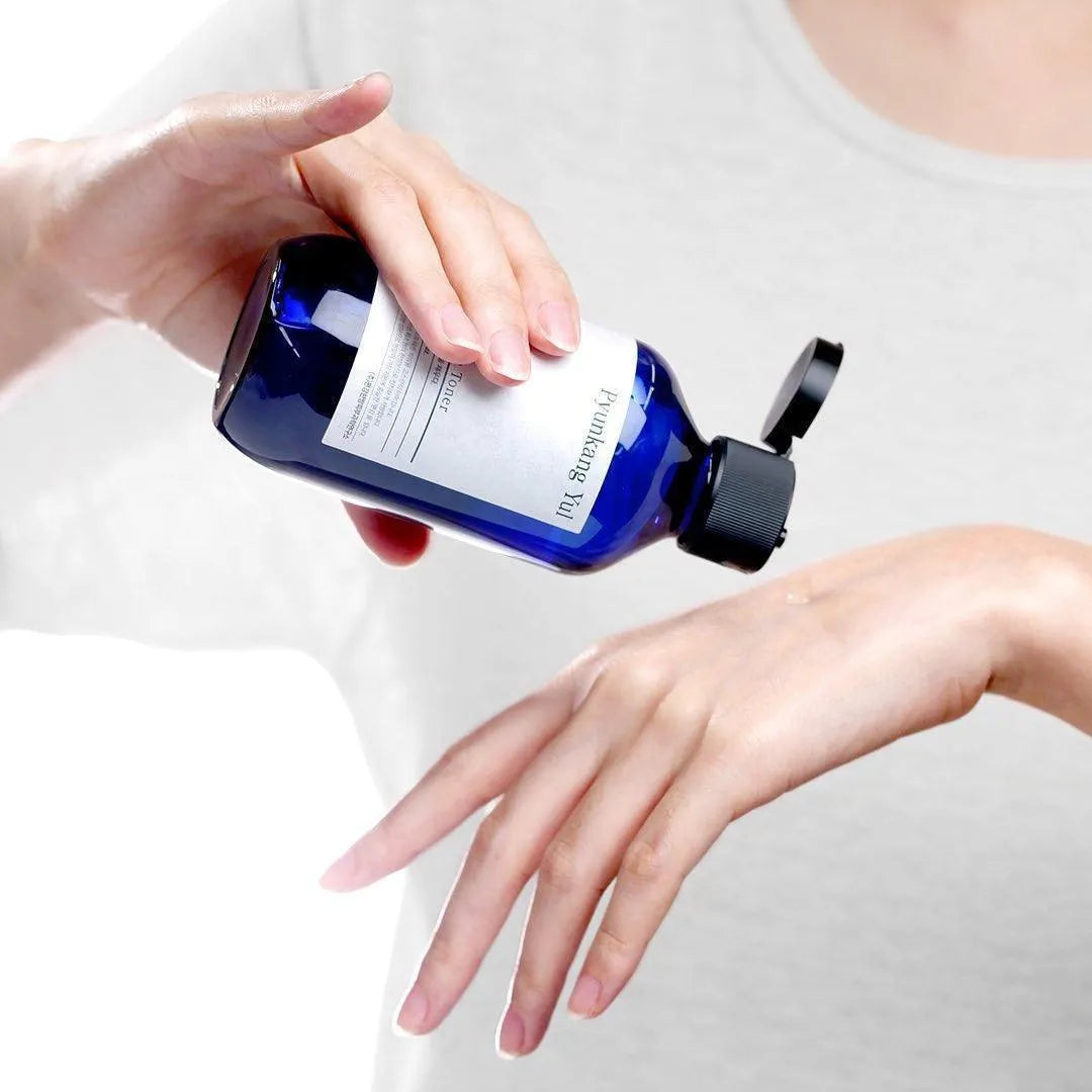 Applying Pyunkang Yul Essence Toner Korean skincare on hand, Me Time Groningen