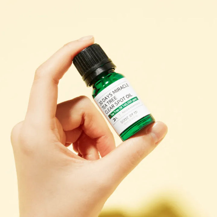 Hand holding Some By Mi 30 Days Miracle Tea Tree Clear Spot Oil, Korean skincare product